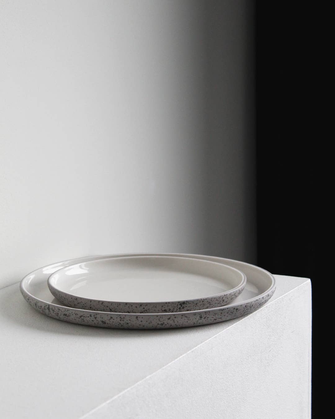 Handgemaakt steengoed bord in lichtgrijs met donkergrijze spikkels – duurzaam en stijlvol servies.